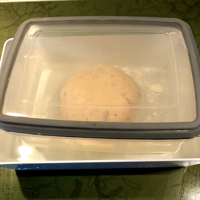 Tomato focaccia - rising dough in a plastic container