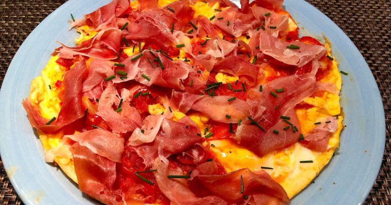 Omelette with red sauce and raw ham